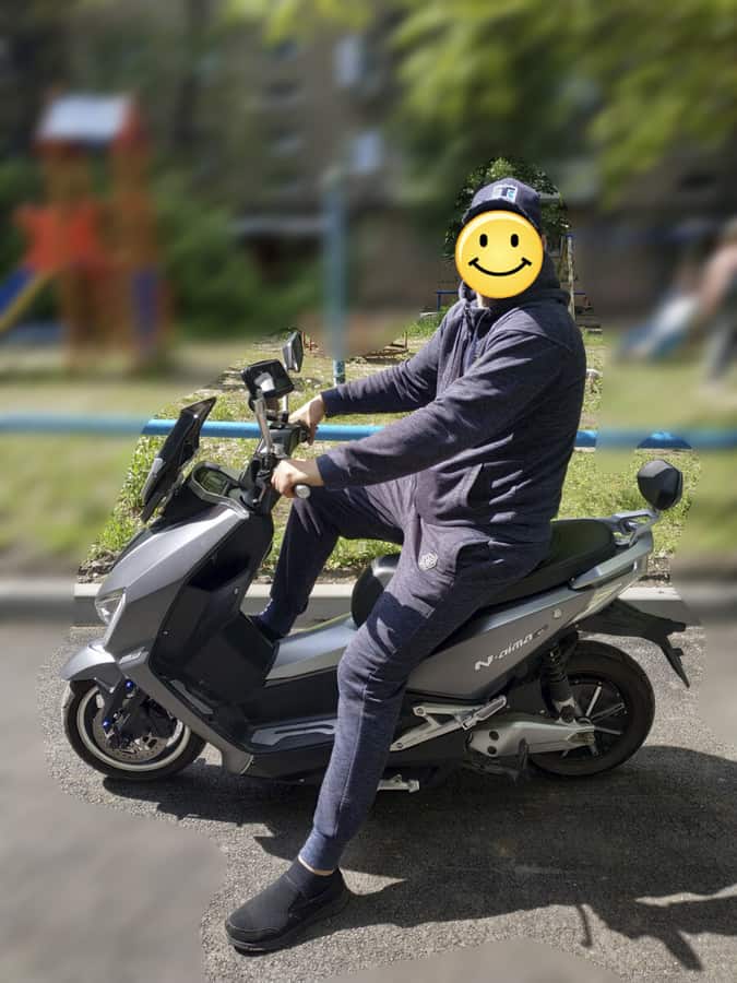 Высокий человек на электроскутере